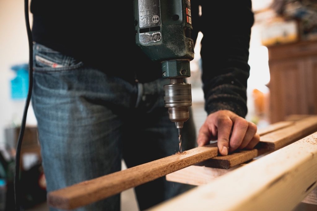 personne qui préparer des plinthes en bois avant de les coller